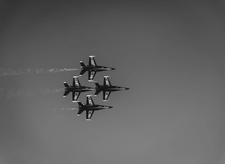 three jets fly side by side in the sky