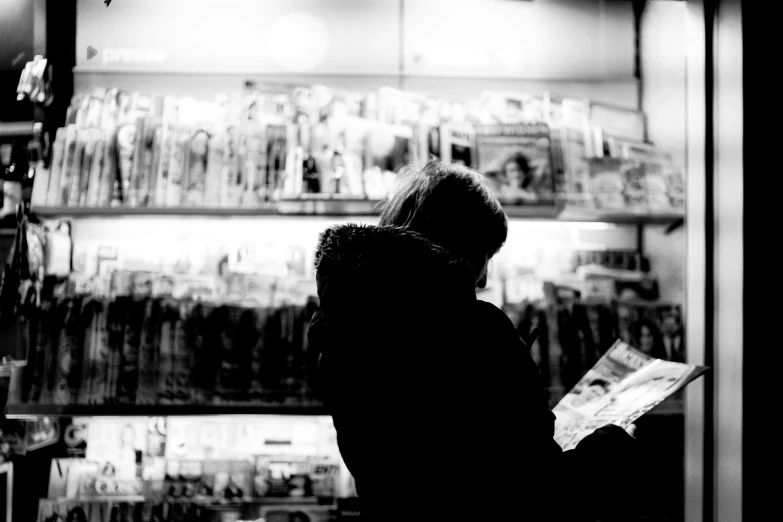 a person standing at a store looking at a paper