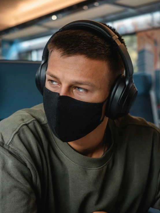 a person wearing headphones and an over - ear black mask