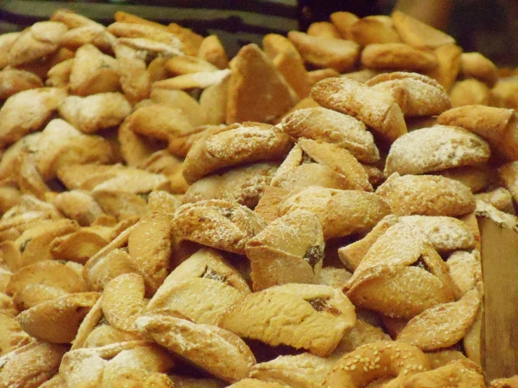 some powdered pastries are in a pile on a wooden surface