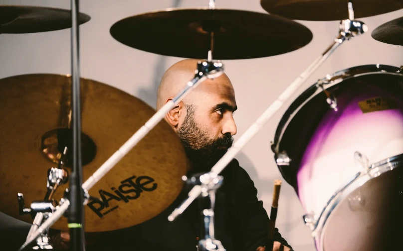 a person sitting next to a drum kit