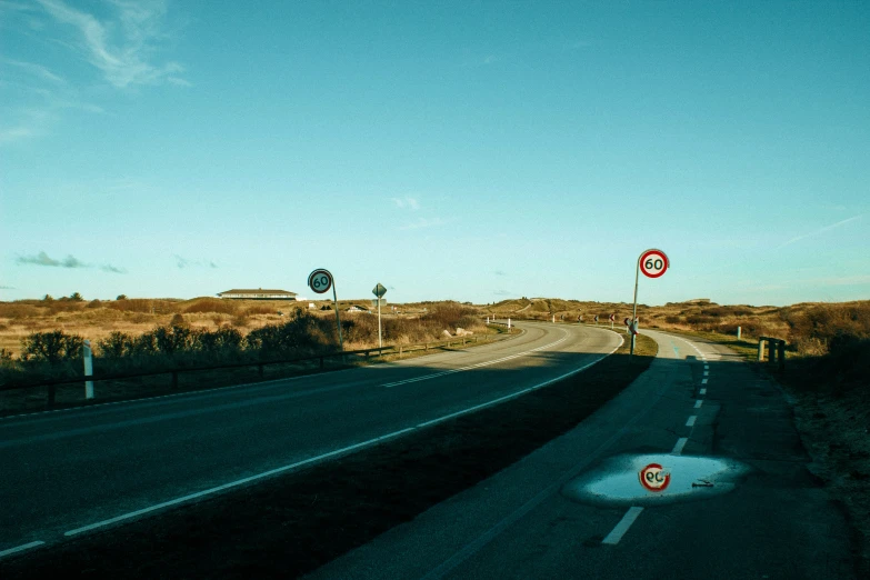 a highway in a field with a stop sign on it