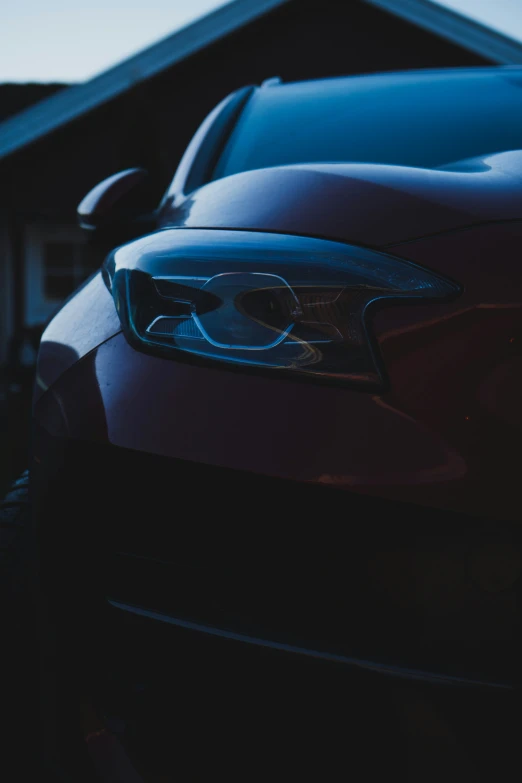 the front view of a blue car in a dark street