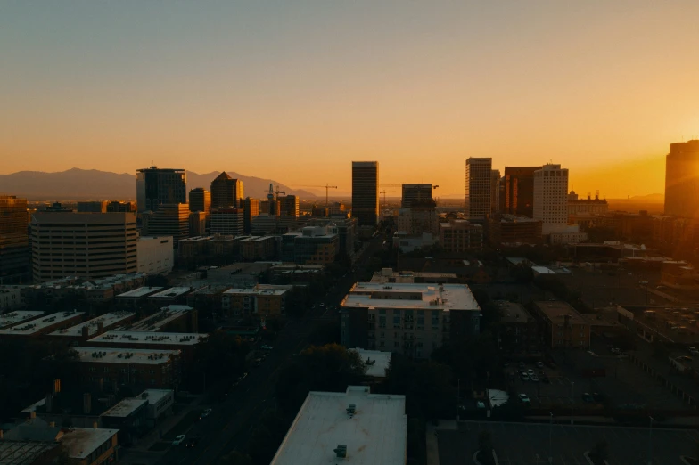 the sun sets behind tall buildings with tall buildings in the background