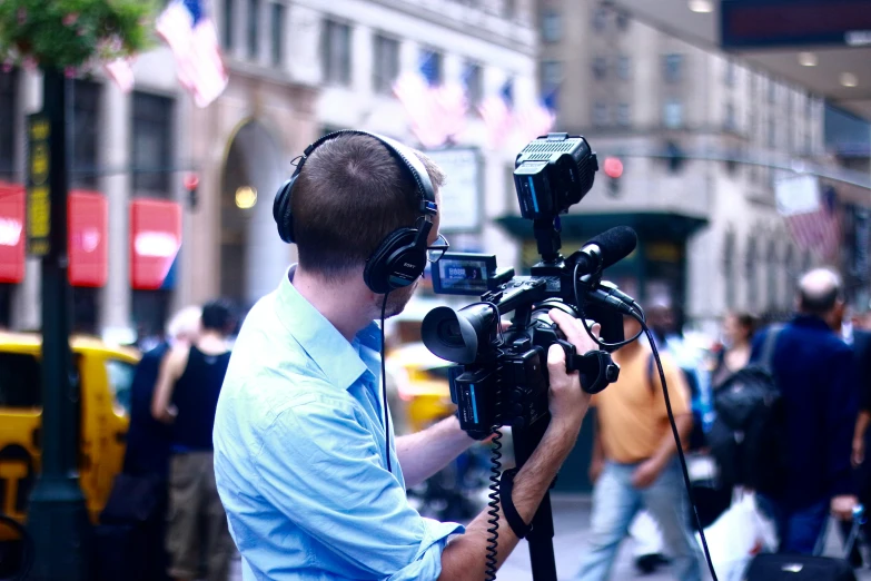 man with headphones on using a video camera