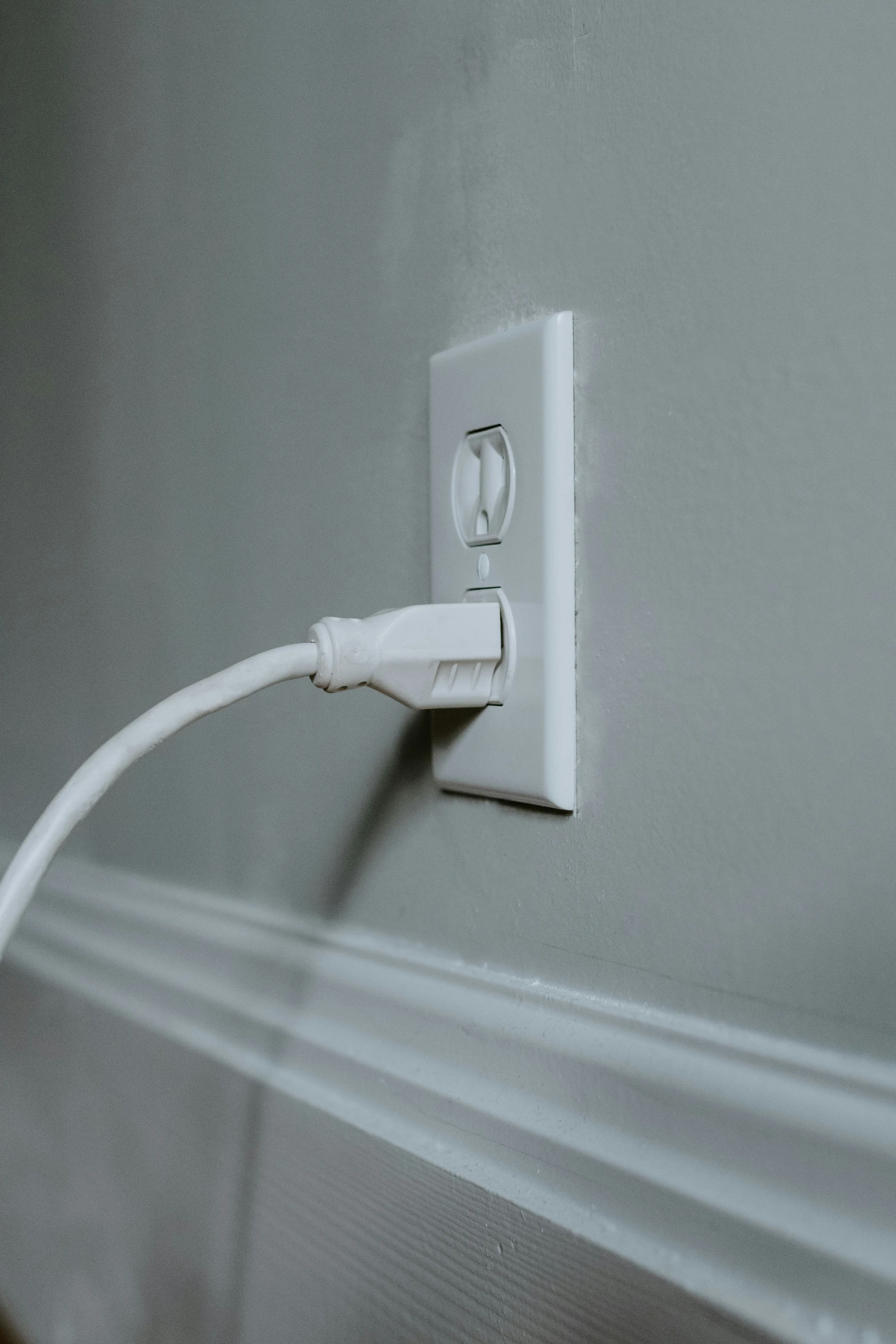 an electrical outlet with a cord running through the wall