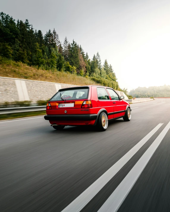 a red car is traveling down the highway