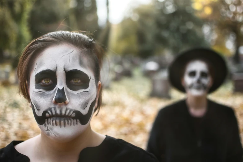 a woman and man with face painted like skulls