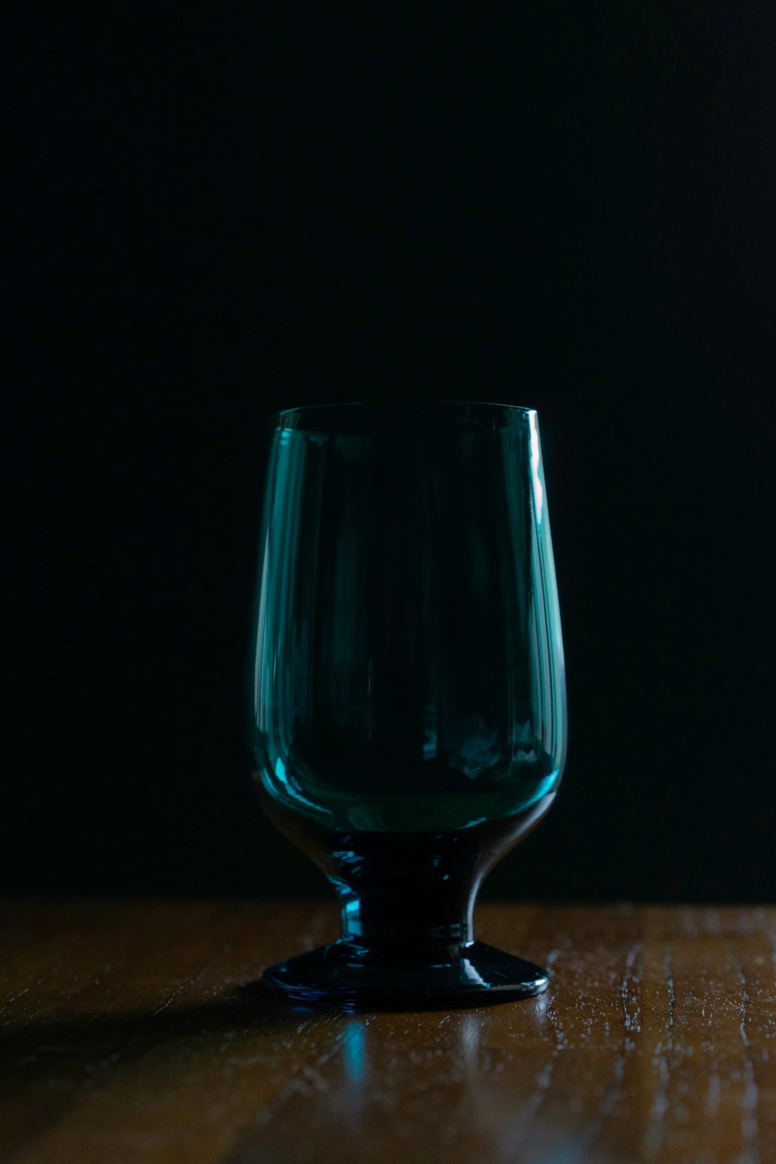 a small clear cup sits on a wooden table