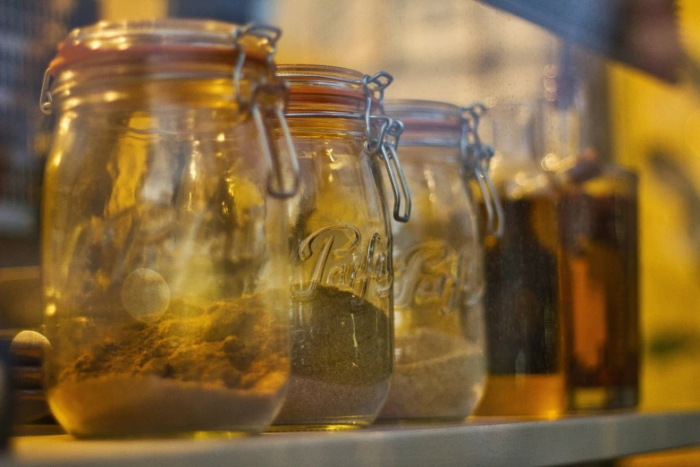 three jars filled with liquid sit on a counter