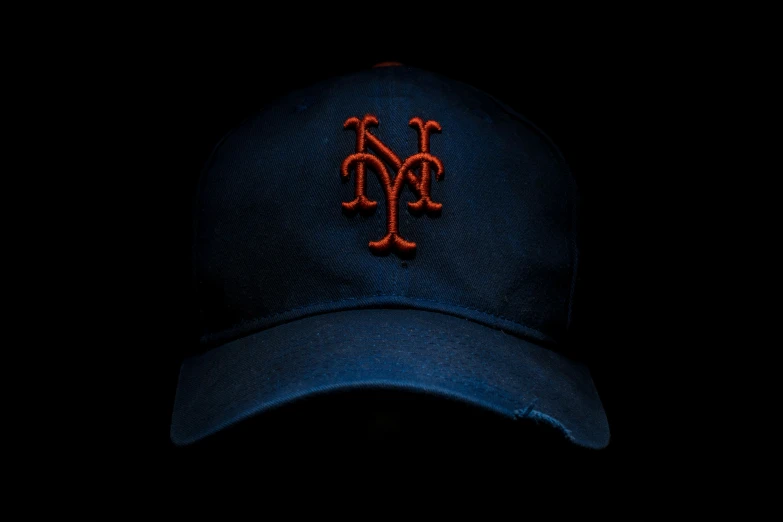 a new york mets cap with a red ny logo on the side of it