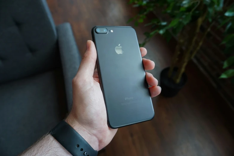 a person holds a black iphone 8 plus