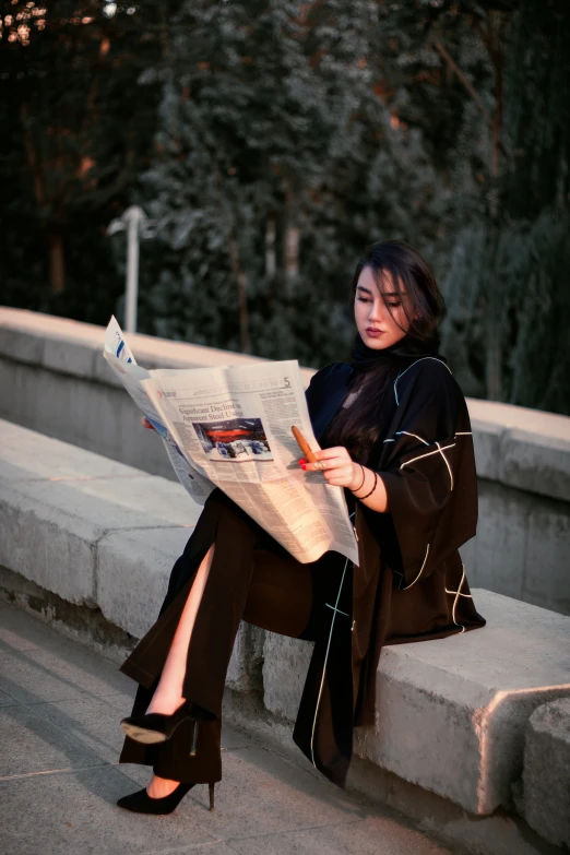 woman sitting on sidewalk looking at the news