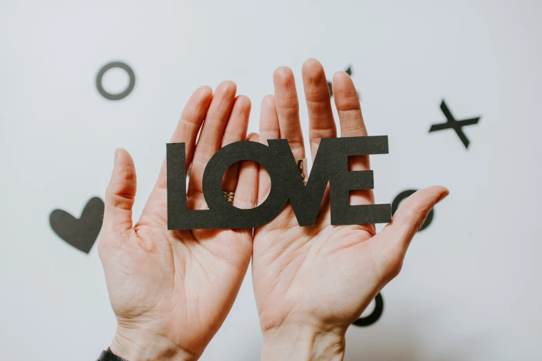 two hands holding up the letters i love in black and white