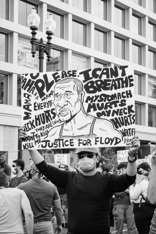 people holding signs outside in a protest with buildings behind