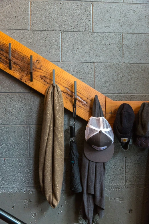 a coat rack is holding hats, scarves and umbrellas