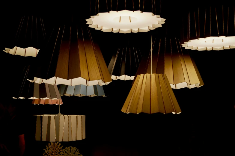 a group of hanging lights with clouds made from paper