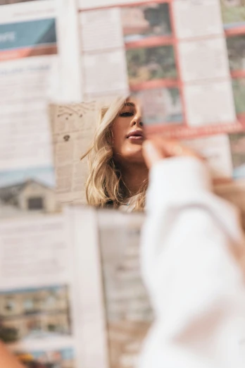 a young woman looks at a pile of newspapers