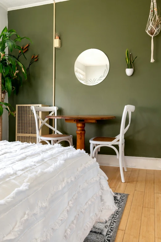 a bedroom with a white bed, mirror, chairs and rug