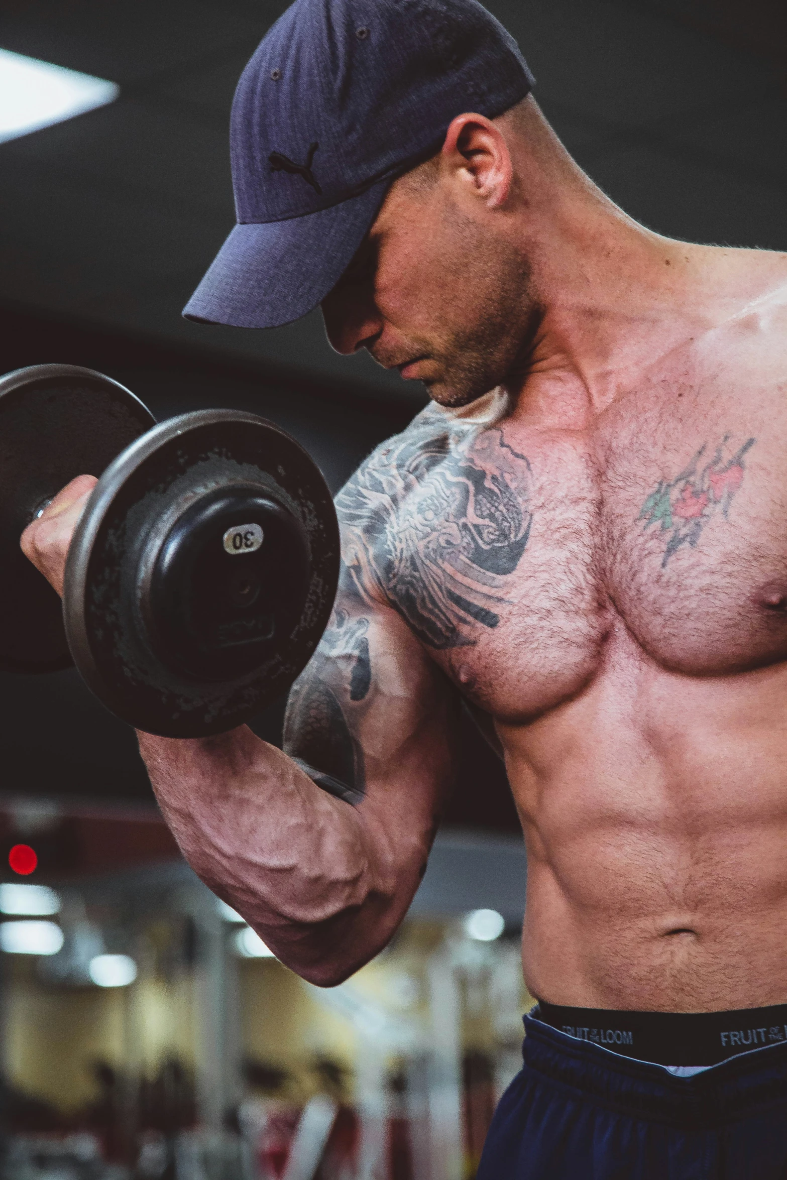 a man in a cap working his muscles with dumb bars