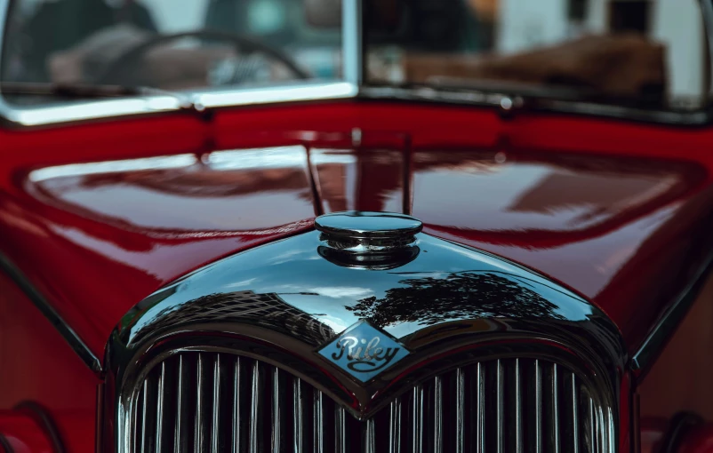 a close up of the front end of an old fashioned red car