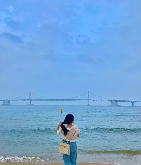 a woman is flying a kite at the beach