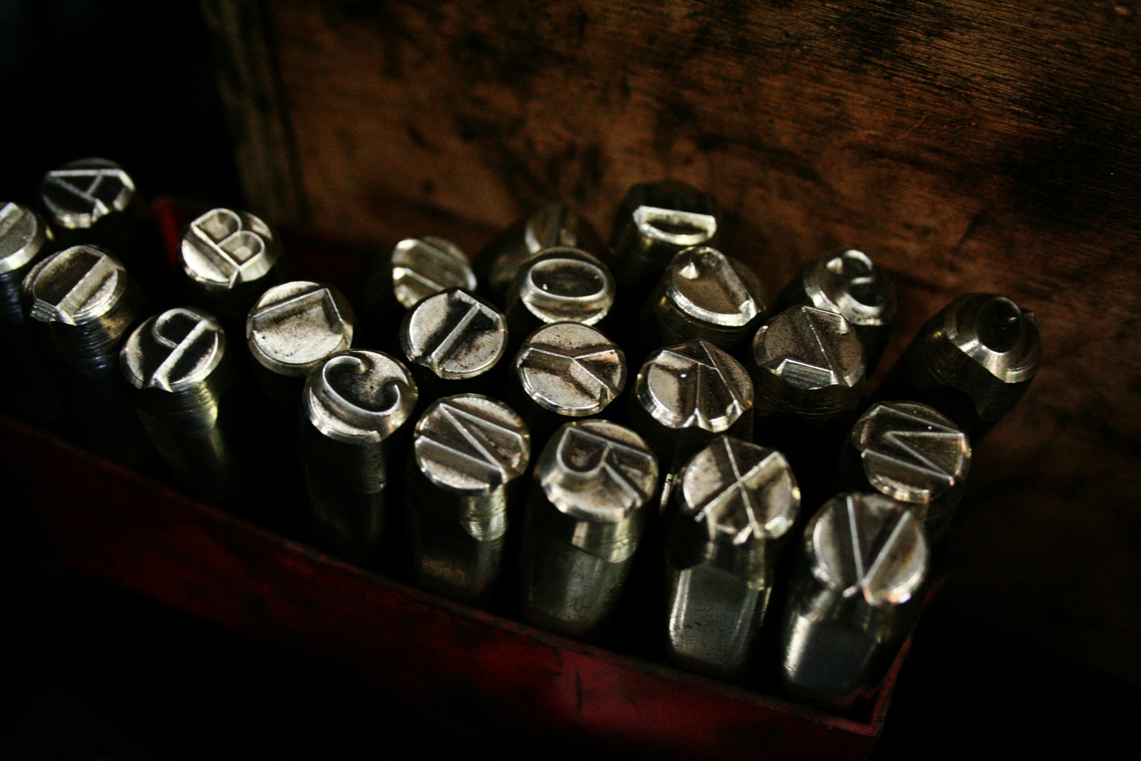 metal crimbells are stacked in a wooden box