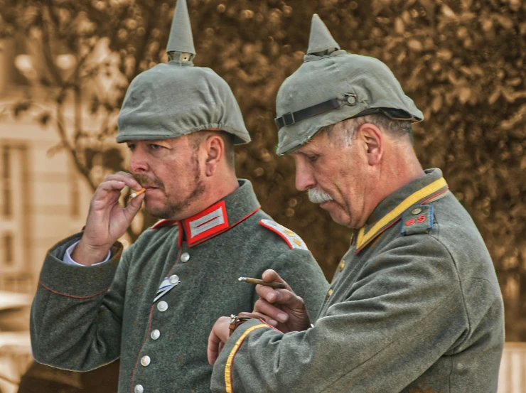 two military men standing side by side smoking