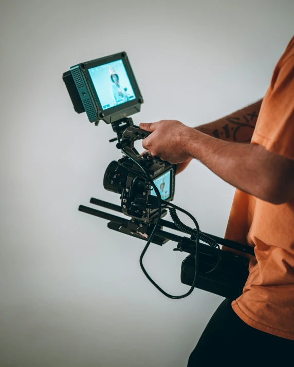 man holding camera attached to his hand held in order to pograph soing