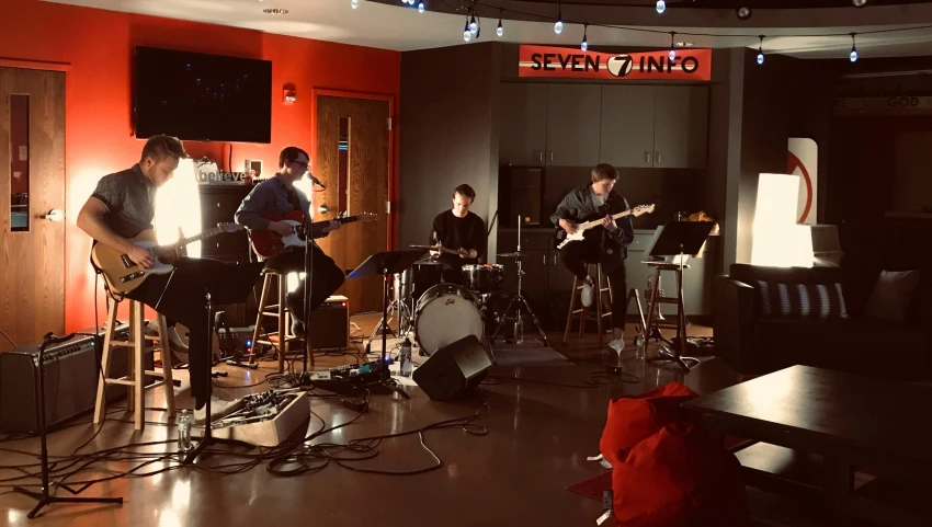 a band plays inside of a room with many stools