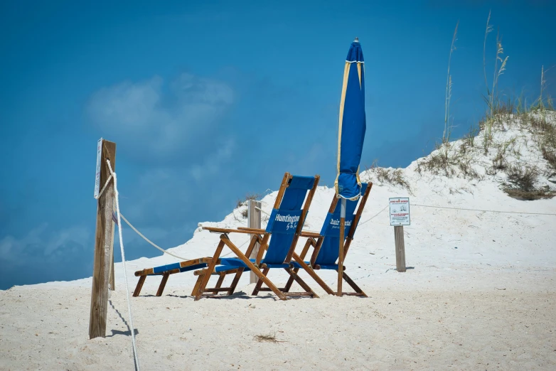 chairs are set up in the sand on a clear day