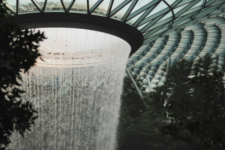 a building is made with a dome that reflects the water being from the fountain