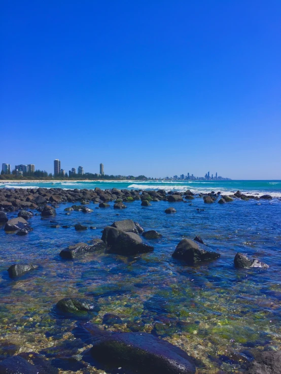 there is a large amount of rocks in the water near the beach