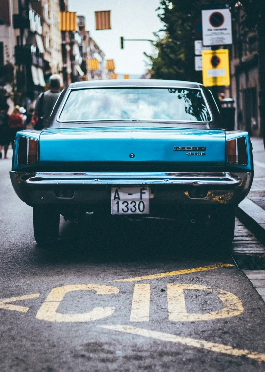 a blue car that is sitting in the street