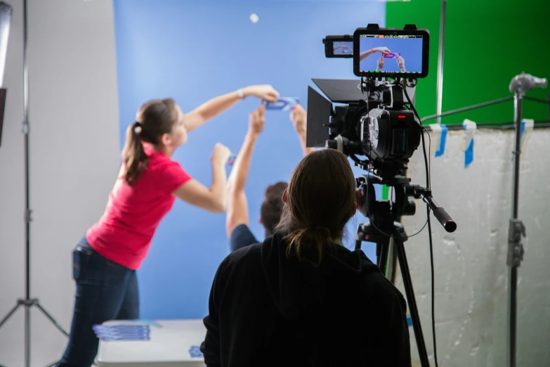 two young women taking pos in front of a camera