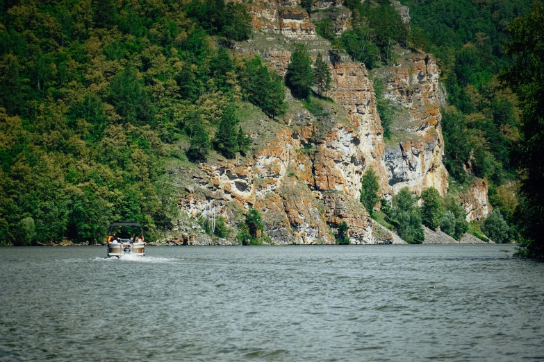 a man riding on the back of a boat across a lake