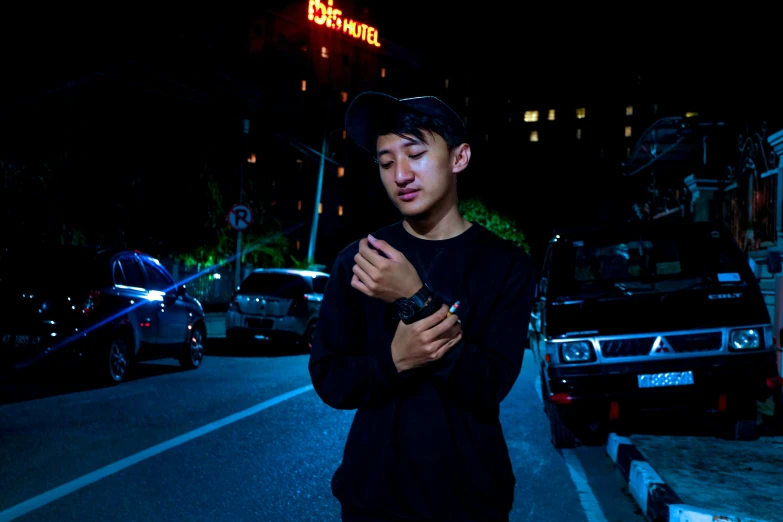 a man standing next to a tall building holding a cell phone