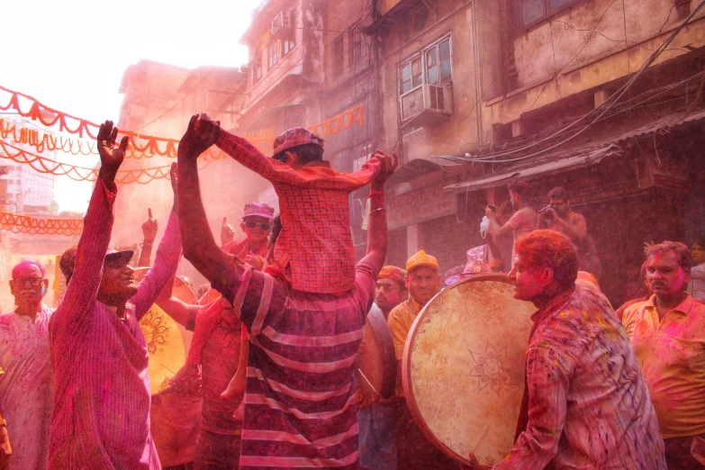 people playing around in a holi ceremony in an old part of india