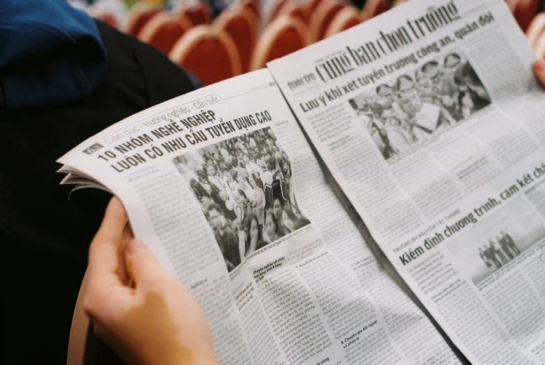 person reading a large group of newspaper articles