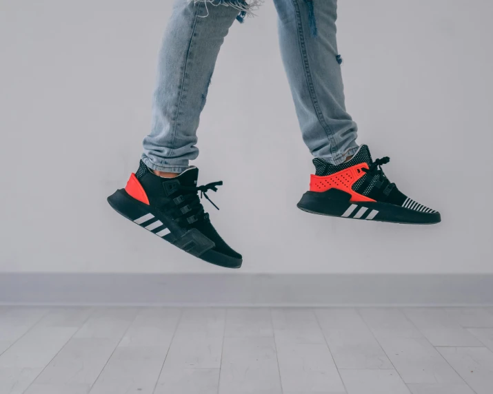 a person's feet dangling from two airy sneakers