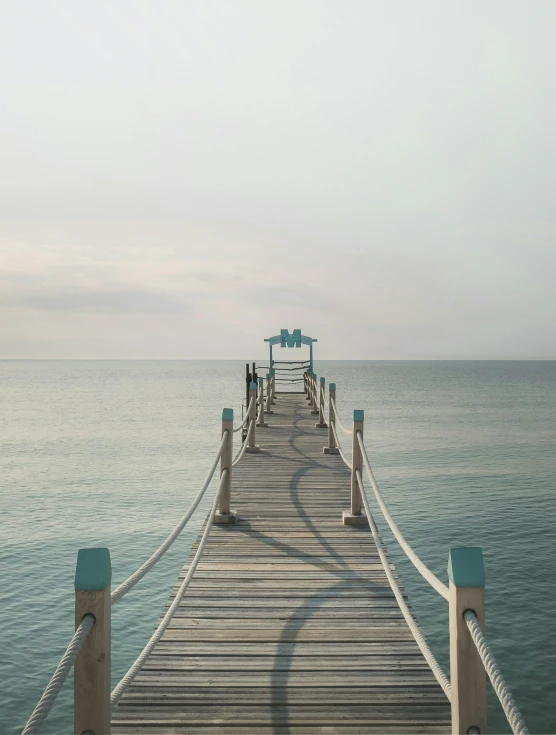 a pier stretching into the ocean on a hazy day