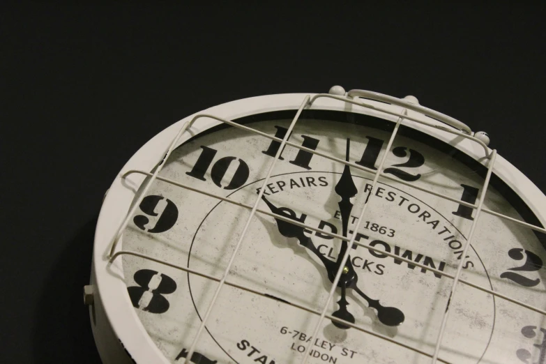 a large white clock that is next to a wall