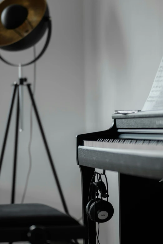 a close - up of the piano with headphones, microphone and tripod