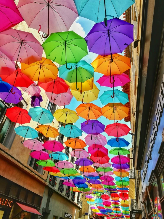 colorful umbrellas hung in the air over a street