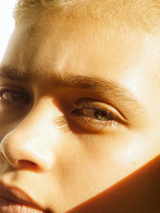 a close up of a person with their face obscured by the sunlight