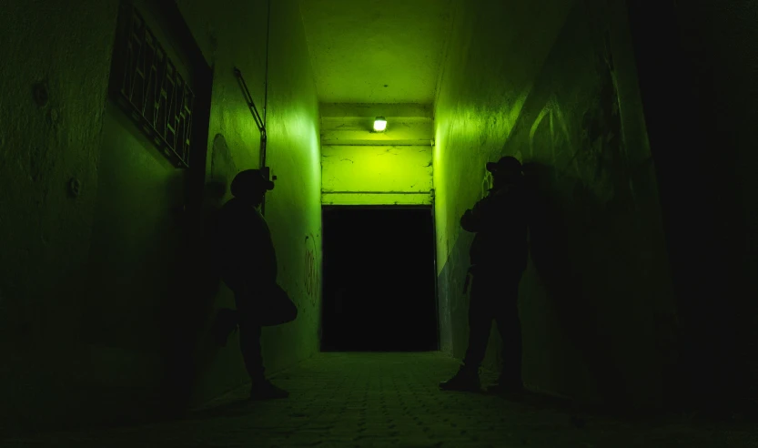 three men standing in a tunnel in the dark