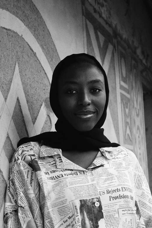 black and white pograph of woman smiling with scarf over her head