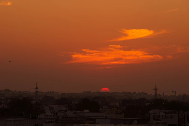 the sun is rising over an area with houses and trees