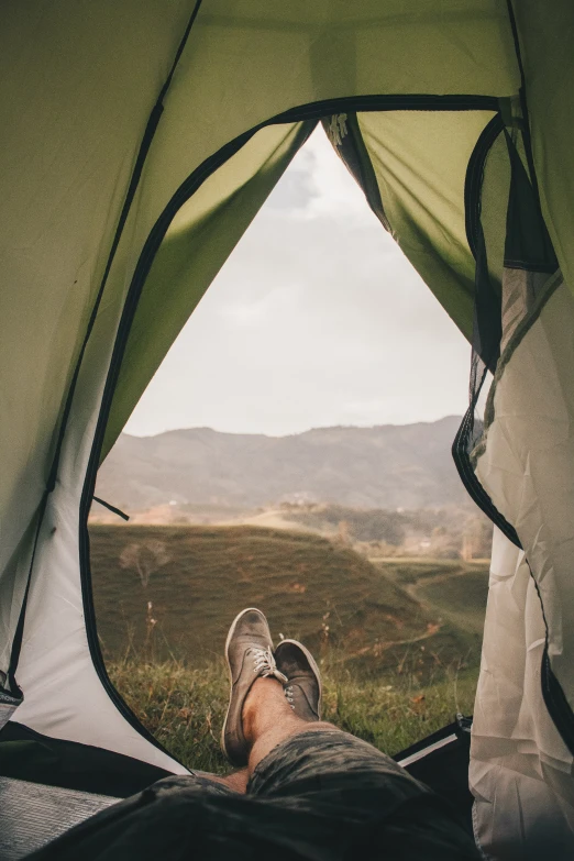 a man standing in front of a tent in the grass