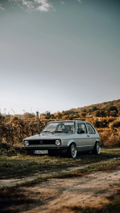 old car sitting on an empty road in an open area